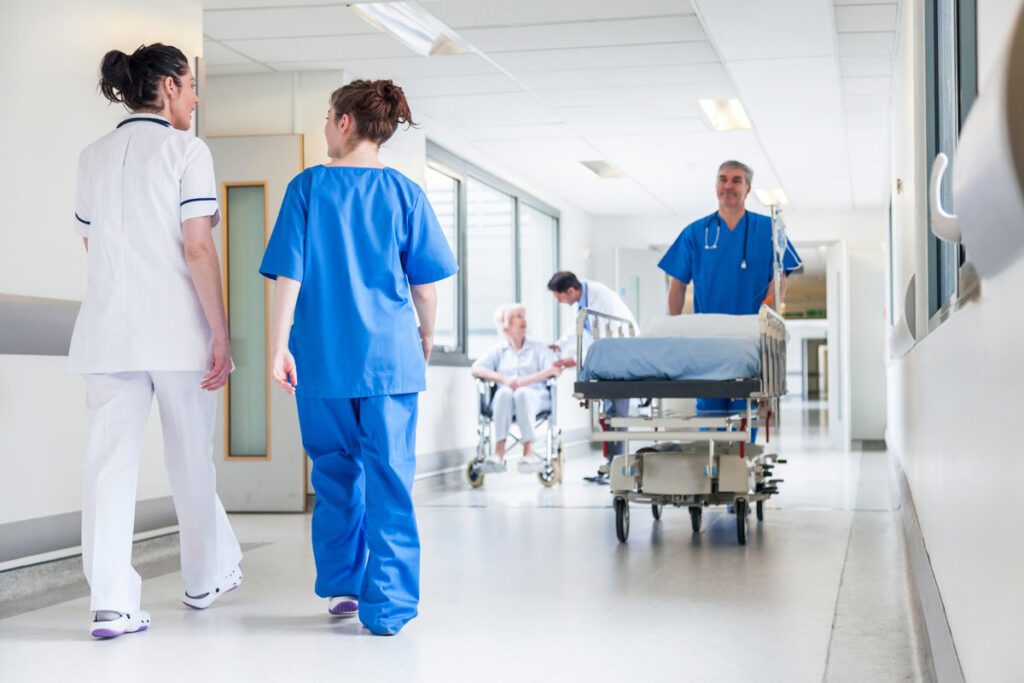 A group of medical professionals walk down a hallway in a healthcare facility - Stroudwater